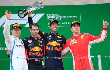 Formula One F1 - Chinese Grand Prix - Shanghai International Circuit, Shanghai, China - April 15, 2018 Red Bull's Daniel Ricciardo celebrates with a trophy on the podium after winning the race as Mercedes' Valtteri Bottas and Ferrari's Kimi Raikkonen look on REUTERS/Aly Song