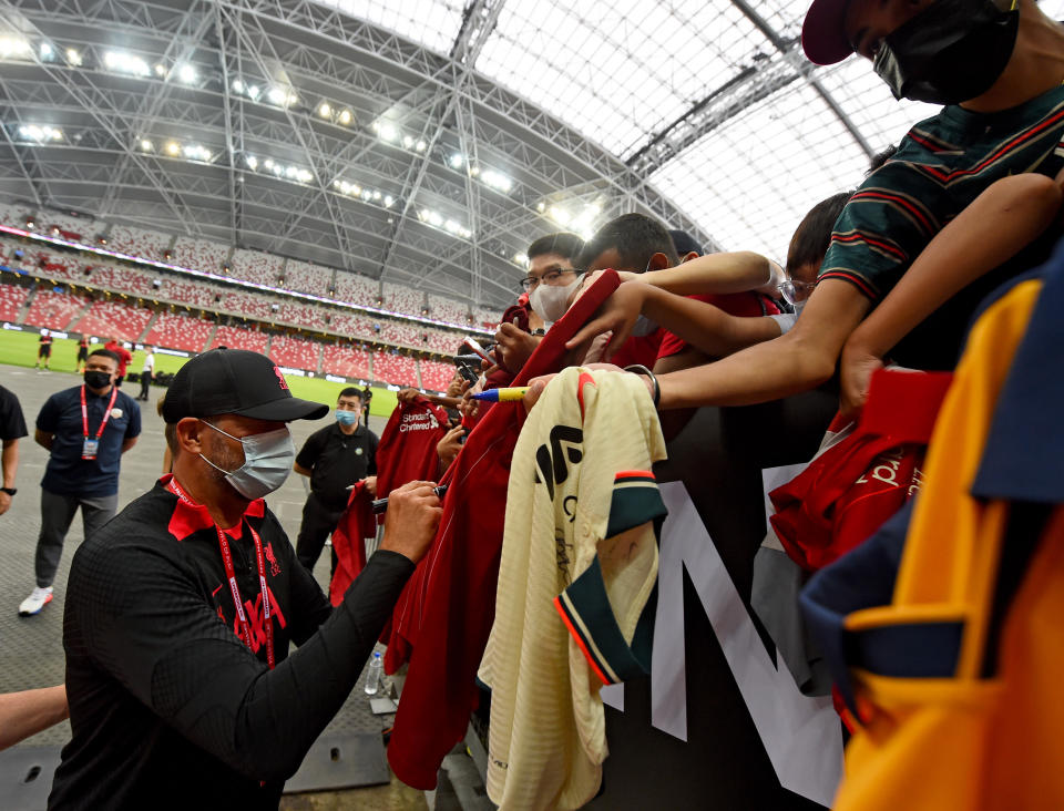 Liverpool manager Jurgen Klopp signing jerseys before a training session at the National Stadium in Singapore.