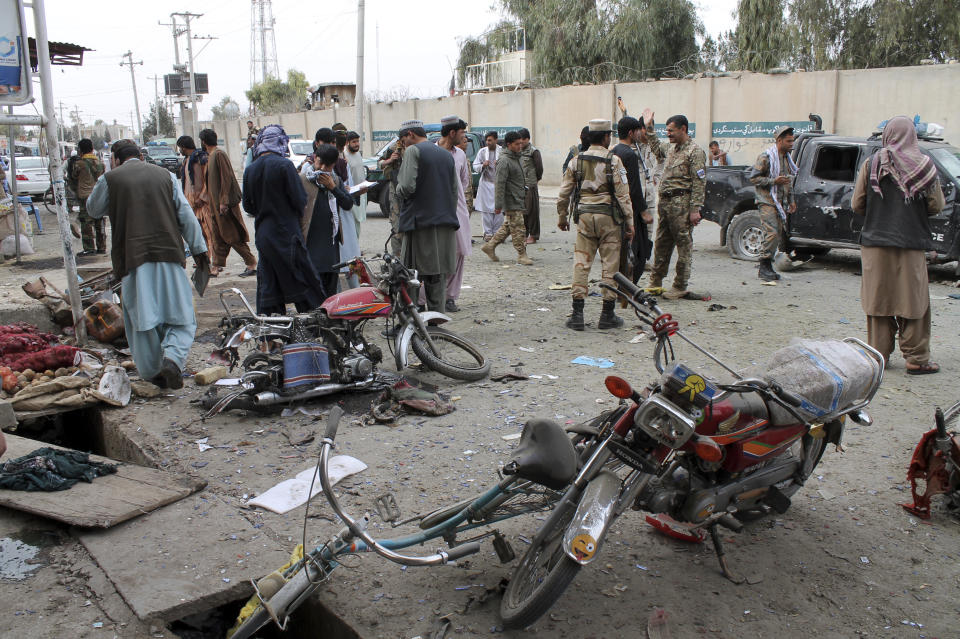 Security personnel inspect the site of a deadly roadside bomb explosion in Helmand province, southern Afghanistan, Sunday, Feb. 21, 2021. Two separate roadside bomb explosions in Afghanistan on Sunday killed and wounded numerous people. (AP Photo/Abdul Khaliq)