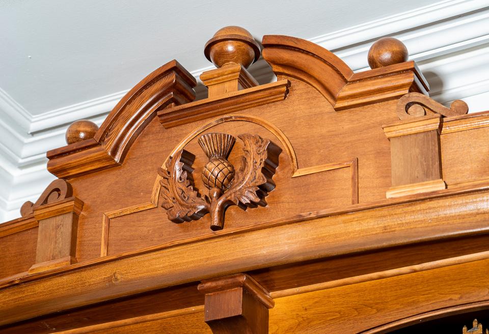 Ron Raasch, owner of Two Hands Restoration, found inspiration from a bank building and the Frame family's Scottish heritage to create an embellishment for the top of a bookcase at the Andrew Frame House in Waukesha, as seen on Dec. 8, 2023.