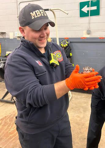 <p>Myrtle Beach Fire Department</p> A Myrtle Beach Fire Department firefighter holding a newborn kitten