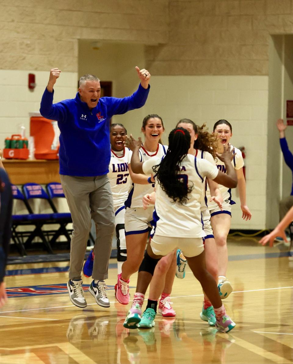 King's Academy girls basketball head coach Chris Race (left) celebrates with his team against Windermere Prep in a playoff game on Monday, Feb. 19, 2024 in West Palm Beach.