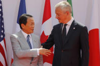 French Finance Minister Bruno Le Maire, right, welcomes Japan's Finance Minister Taro Aso at the G-7 Finance Wednesday July 17, 2019.The top finance officials of the Group of Seven rich democracies are arriving at Chantilly, at the start of a two-day meeting aimed at finding common ground on how to tax technology companies and on the risk from new digital currencies. (AP Photo/Michel Euler)