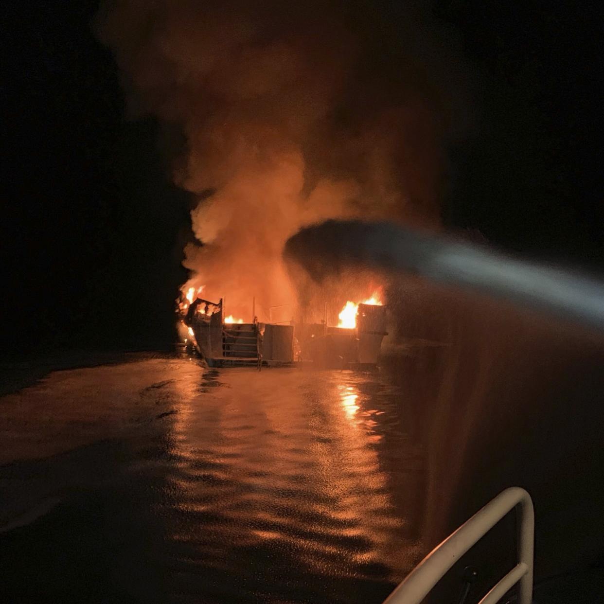 In this photo provided by the Ventura County Fire Department, VCFD firefighters respond to a boat fire off the coast of southern California, Monday, Sept. 2, 2019. The U.S. Coast Guard said it has launched several boats to help over two dozen people "in distress" off the coast of southern California. (Ventura County Fire Department via AP)
