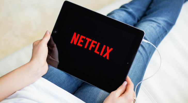 the netflix logo displayed on a tablet that a person is holding while laying down