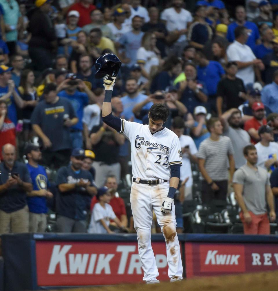 Christian Yelich tips his cap to the fans after hitting a triple for the cycle.