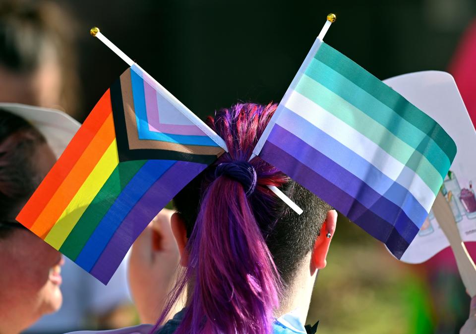 An attendee of the Louisville Pride Festival displays pride flags, Saturday, Sept. 17 2022 in Louisville Ky.