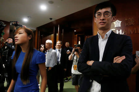 Activists Baggio Leung (R) and Yau Wai-ching (L) stand outside the chamber after pro-Beijing lawmakers staged a walk-out to stall their swearing-in at the Legislative Council in Hong Kong, China October 19, 2016. REUTERS/Bobby Yip