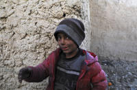 An internally displaced boy poses for a photograph outside his temporary home in the city of Kabul, Afghanistan, Wednesday, Dec. 30, 2020. Save the Children has warned that more than 300,000 Afghan children face freezing winter conditions that could lead to illness, in the worst cases death, without proper winter clothing and heating. (AP Photo/Rahmat Gul)