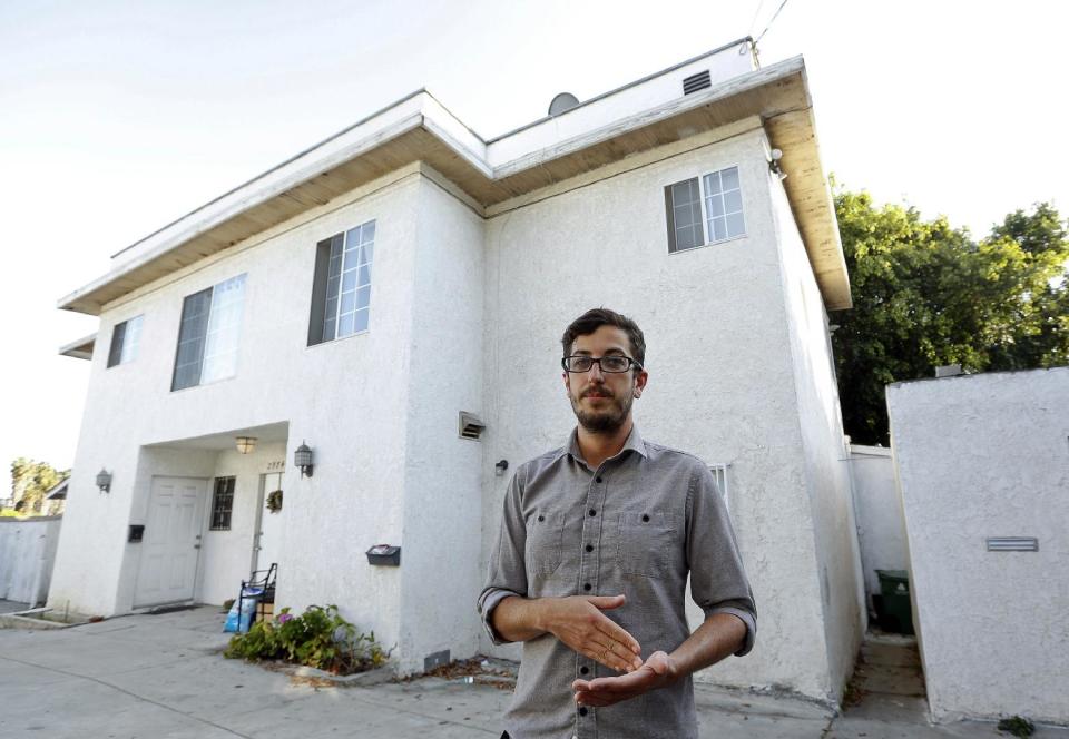 In this Thursday, March, 27, 2014 photo, Marc Caswell, who recently moved from San Francisco to Los Angeles, poses for a photo in front of his newly rented apartment in the Los Feliz district of Los Angeles. Rising rents in San Francisco compelled Marc Caswell to move to Los Angeles in September. (AP Photo/Damian Dovarganes)