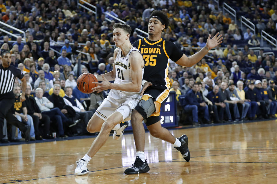 Michigan guard Franz Wagner (21) drives against Iowa forward Cordell Pemsl (35) in the first half of an NCAA college basketball game in Ann Arbor, Mich., Friday, Dec. 6, 2019. (AP Photo/Paul Sancya)