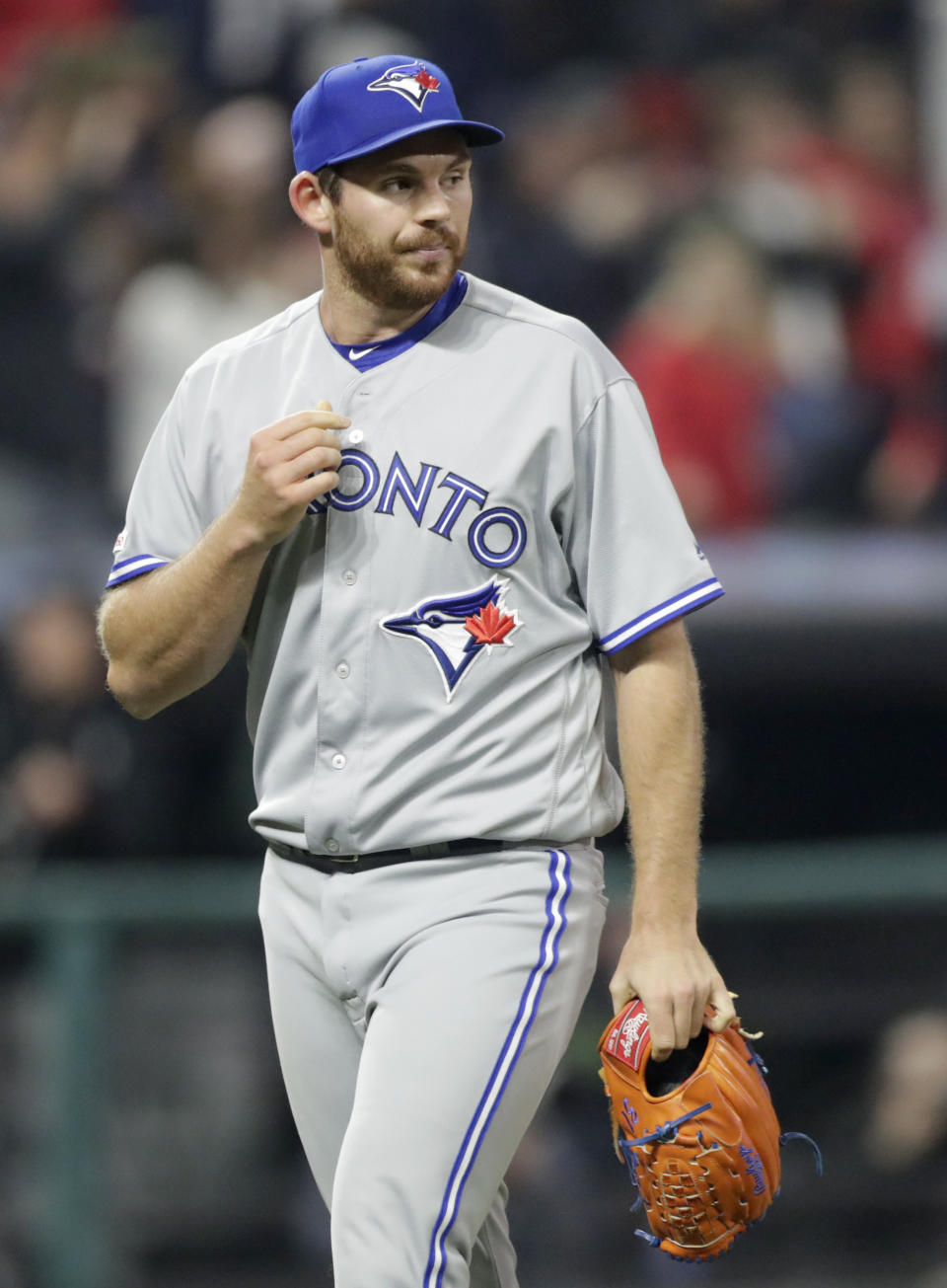 Toronto Blue Jays relief pitcher Joe Biagini walks off the field after Cleveland Indians' Carlos Santana hit a solo home run during the ninth inning of a baseball game, Friday, April 5, 2019, in Cleveland. The Indians won 3-2. (AP Photo/Tony Dejak)