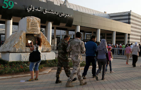 Syrian army soldiers walk at the Damascus International Fair in Damascus, Syria August 20, 2017. REUTERS/Omar Sanadiki