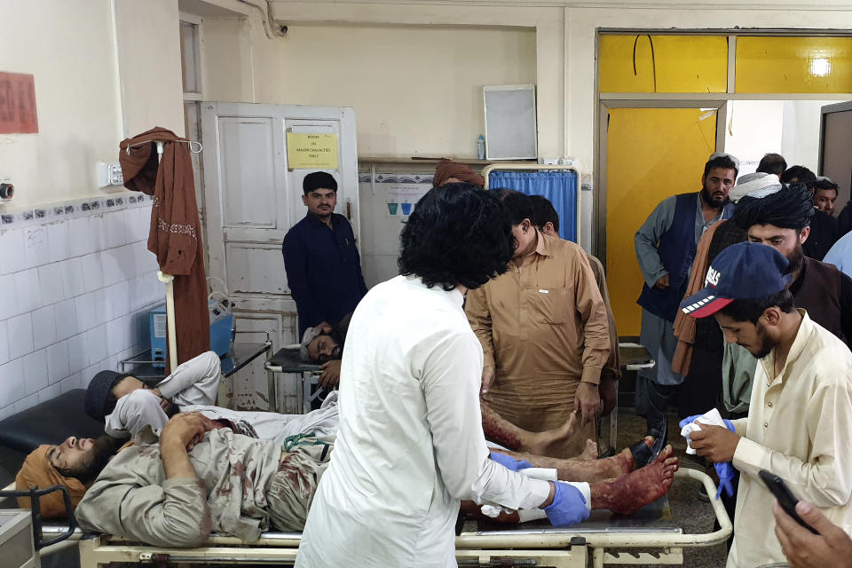 A Pakistani paramedic treats men, who were injured in a fighting between Afghan security forces and Taliban in Spin Boldak border area, at a hospital in Chaman, Pakistan, Friday, July 16, 2021. Afghan government security forces were battling to retake the southeastern Spin Boldak border crossing with neighbor Pakistan Friday, according to Afghanistan's deputy defense ministry spokesman Fawad Awan. (AP Photo/Tariq Achakzai)