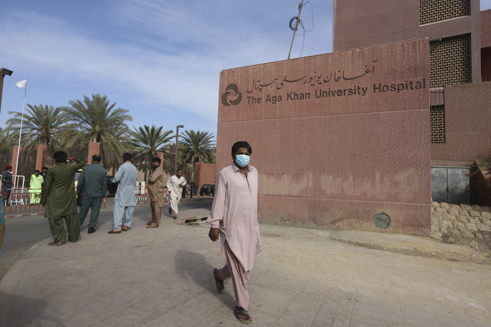 A Pakistani man wearing a face mask walks past the Aga Khan hospital where a patient suspected of having contracted coronavirus was admitted, in Karachi, Pakistan, Thursday, Feb. 27, 2020. (AP Photo/Fareed Khan)