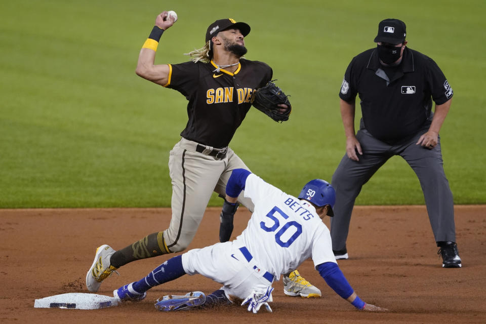 San Diego Padres' Fernando Tatis Jr., top, forces out Los Angeles Dodgers' Mookie Betts (50) during the first inning in Game 2 of a baseball National League Division Series Wednesday, Oct. 7, 2020, in Arlington, Texas. (AP Photo/Tony Gutierrez)