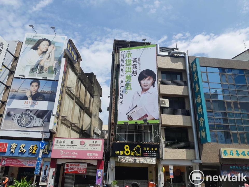 黃露慧爭取民進黨主委連任的競選看板也掛在中央噴水圓環旁。   圖：蔡坤龍/攝