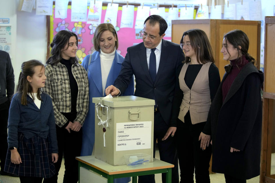 Presidential candidate Nikos Christodoulides, escorted by his wife Philippa and their daughters, casts his vote during the presidential elections in Geroskipou in south west coastal city of Paphos, Cyprus, Sunday, Feb. 12, 2023. Voting has started in a runoff to elect ethnically split Cyprus' eighth new president, pitting a former foreign minister who campaigned as a unifier eschewing ideological and party divisions against a popular veteran diplomat. Some 561,000 citizens are eligible to vote Sunday and both Nikos Christoulides, the ex-foreign minister and Andreas Mavroyiannis are hoping for a higher turnout than the 72% that cast ballots in Feb. 5 first round. (AP Photo/Petros Karadjias)