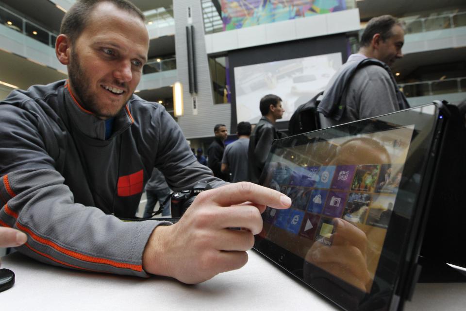 John Eversole, a marketing manager for Microsoft, uses a Samsung Series 7 Slate device with the new Windows 8 operating system during an event unveiling a new Microsoft Windows operating system Thursday, Oct. 25, 2012, at the company's headquarters in Redmond, Wash. Windows 8, attempts to bridge the gap between personal computers and fast-growing tablets with its touch-enabled interface. It is the most dramatic overhaul of the personal computer market's dominant operating system in 17 years. (AP Photo/Elaine Thompson)