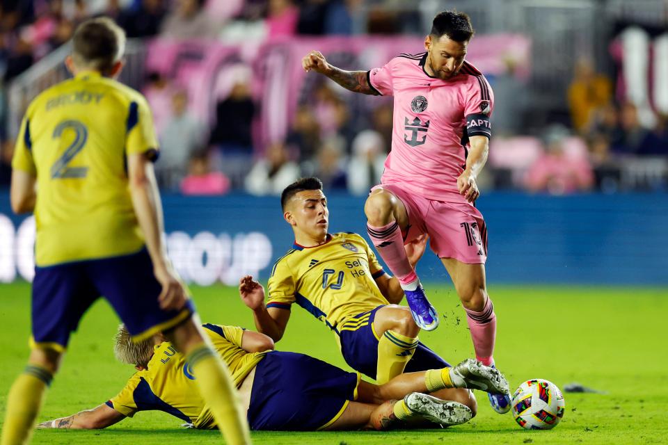 Lionel Messi #10 of Inter Miami dribbles against Diego Luna #8 and Braian Ojeda #6 of Real Salt Lake during the first half at Chase Stadium on February 21, 2024 in Fort Lauderdale, Florida.