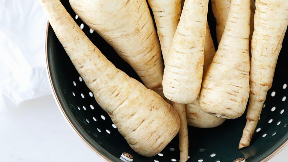 still life of fresh parsnips in a colander