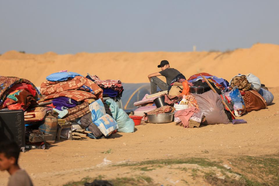 A Displaced Palestinian sits with his belongings at a camp in Rafah, on the southern Gaza Strip, after fleeing Khan Yunis on December 4, 2023.