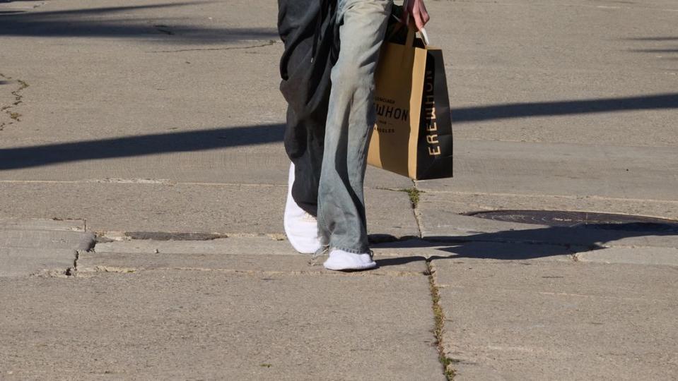 a balenciaga model walking down a street in la during balenciaga's fall 2024 runway show