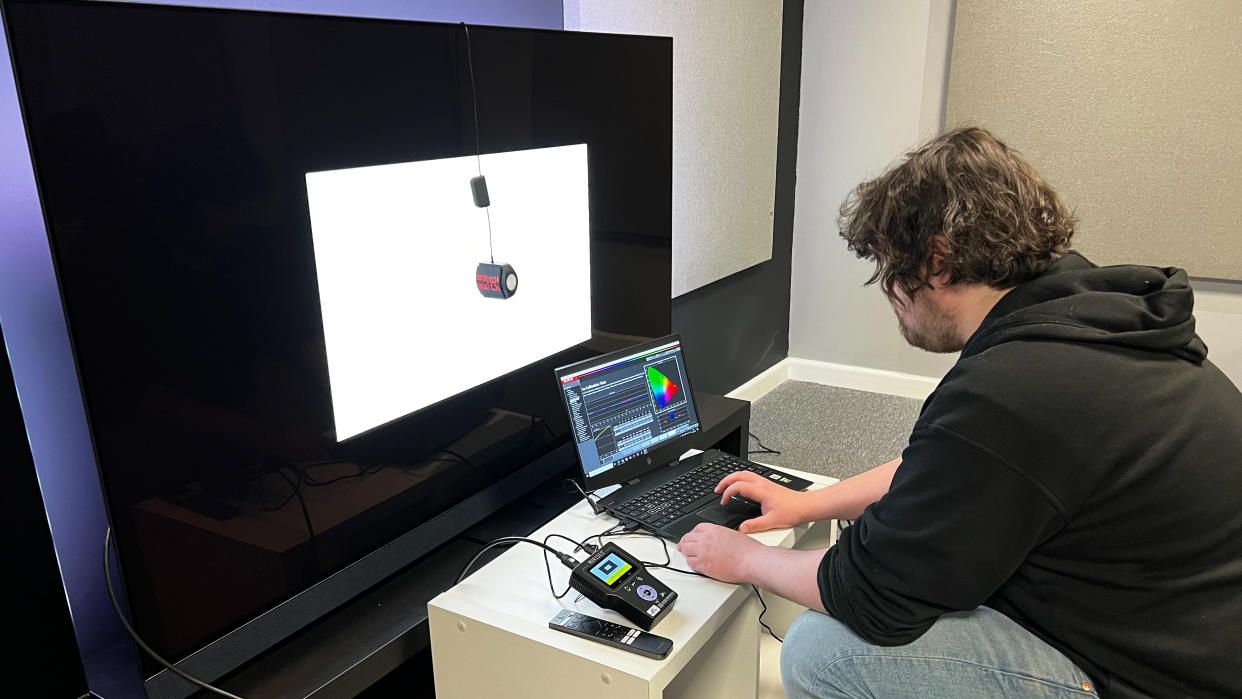  TechRadar reviewer measuring TV color gamut coverage with test equipment. 