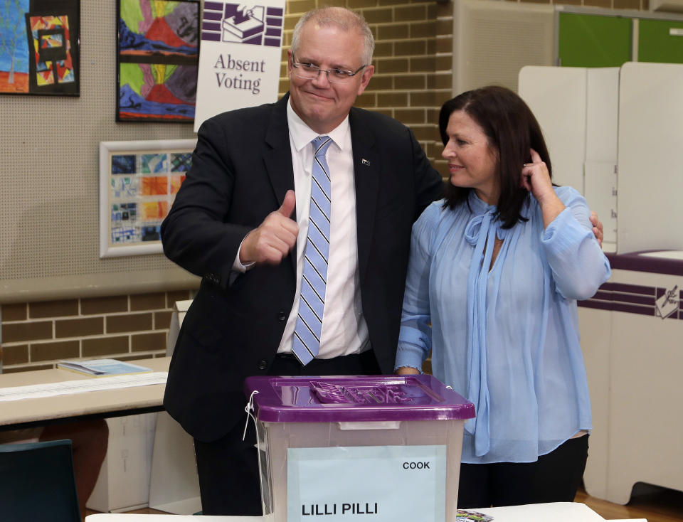 Australian Prime Minister Scott Morrison, left, gestures while holding his wife, Jenny, after casting his ballot in a federal election in Sydney, Australia, Saturday, May 18, 2019. Political leaders continued frenetic 11th-hour campaigning as Australians vote on Saturday in an election likely to deliver the nation's sixth prime minister in as many years. (AP Photo/Rick Rycroft)