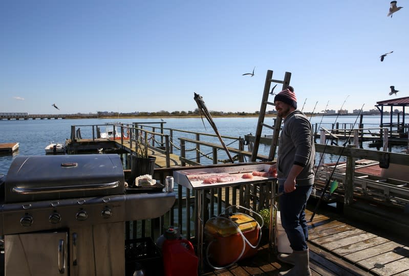 Chris Keegan prepara trozos de una lubina rayada pescados, fuera de la casa de Keegan, en el vecindario de Broad Channel de Queens, en la ciudad de Nueva York, EEUU, el 2 de noviembre de 2019