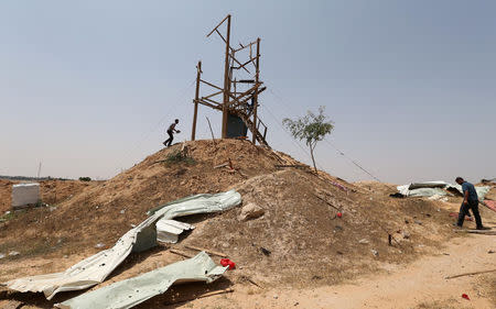 Palestinians inspect an Islamic Jihad observation post after it was targeted in Israeli tank shelling, in the southern Gaza Strip May 27, 2018. REUTERS/Ibraheem Abu Mustafa