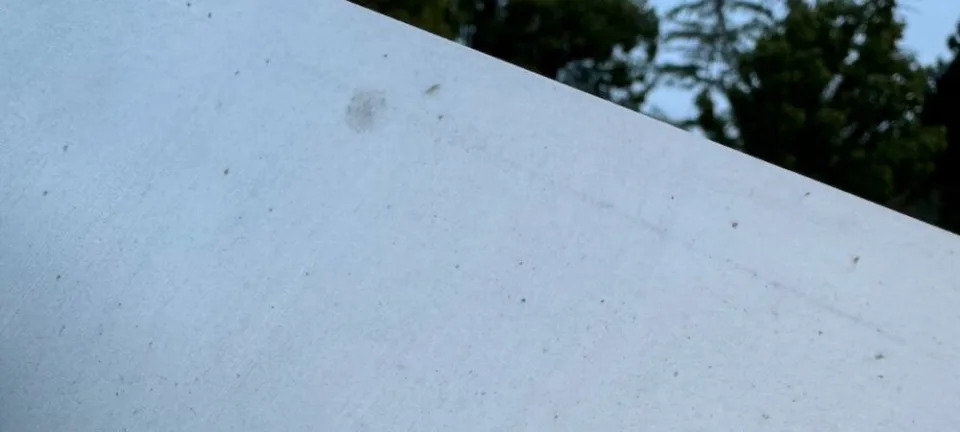 A Cybertruck body panel pockmarked with small orange spots