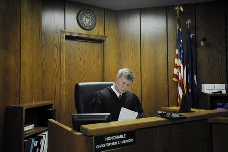 Judge Christopher Haenicke fills out paperwork after the arraignment of Jason Dalton (not shown) on closed circuit television in Kalamazoo County, Michigan February 22, 2016. REUTERS/Mark Kauzlarich