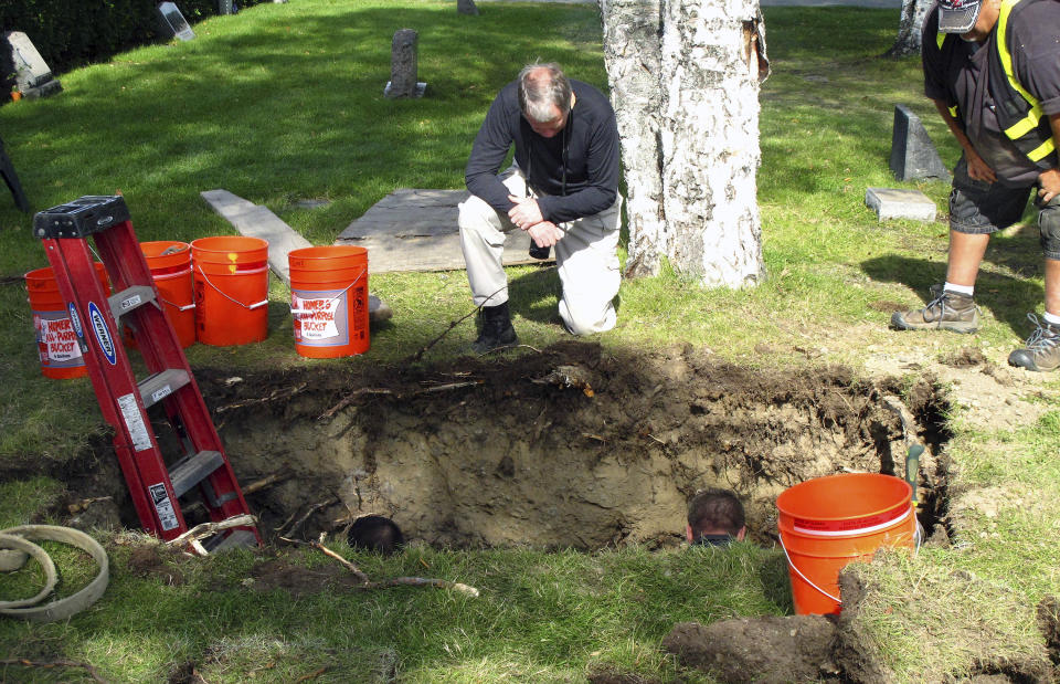 CORRECTS VICTIM'S NAME TO ROBIN PELKEY, INSTEAD OF HARRIET ROBIN PELKEY - FILE - In this Sept. 3, 2014, file photo, workers and medical examiner crew members exhume the body of Jane Doe #3 from a cemetery in Anchorage, Alaska. The remains of a woman known for 37 years only as Horseshoe Harriet, one of 17 victims of a notorious Alaska serial killer, have been identified through DNA profiling as Robin Pelkey, authorities said Friday, Oct. 22, 2021. (AP Photo/Rachel D'Oro, File)