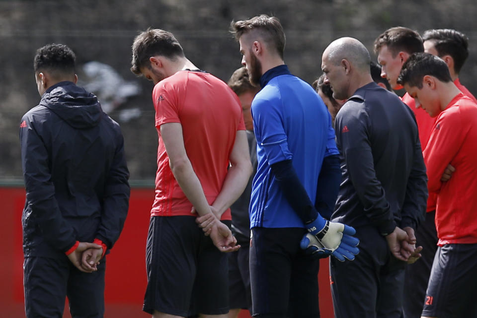 Manchester United soccer players and staff stand for a minute of silence during training honoring the people killed and wounded in the attack at the Ariana Grande concert.