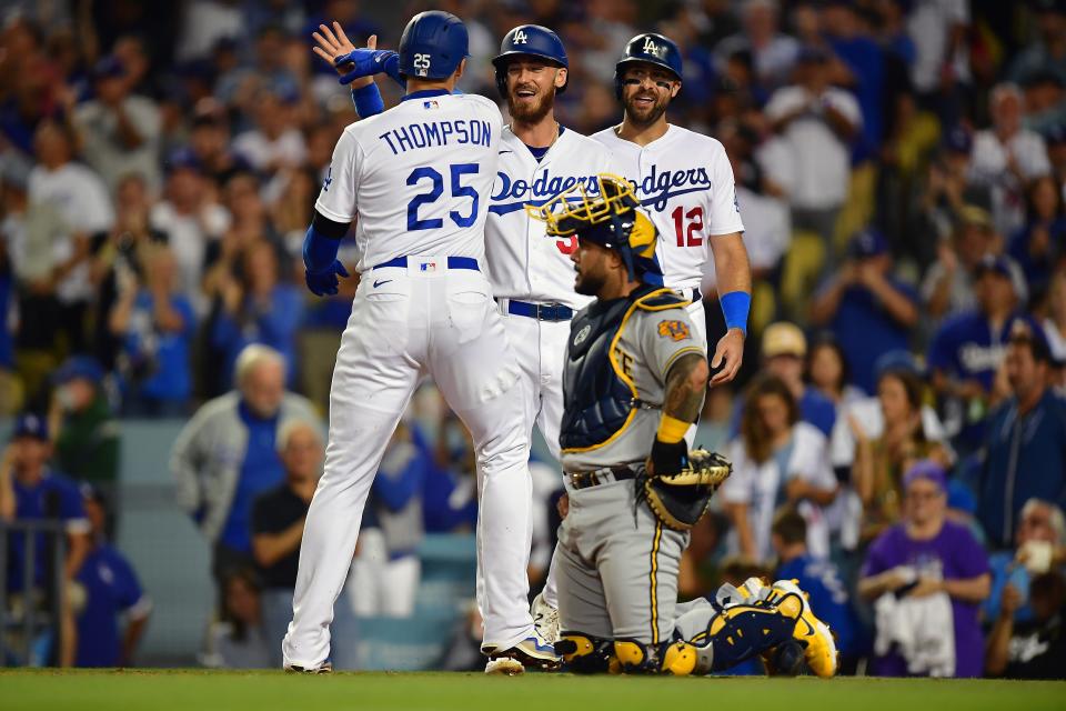 Los Angeles Dodgers designated hitter Trayce Thompson (25) is greeted by center fielder Cody Bellinger (35) and left fielder Joey Gallo (12) after hitting a three run home run against the Milwaukee Brewers during the second inning at Dodger Stadium.