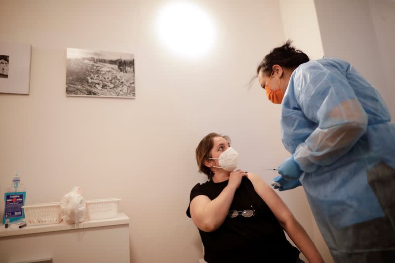 A woman reacts after being vaccinated against COVID-19, at Bran castle