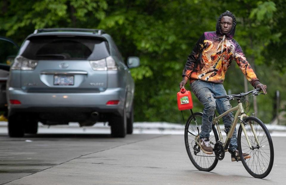 Tairez Coleman uses his bike for transportation after filling a can with gas at the Circle K on Avent Ferry Road on Wednesday, May 12, 2021 in Raleigh, N.C. after his car ran out of gas.