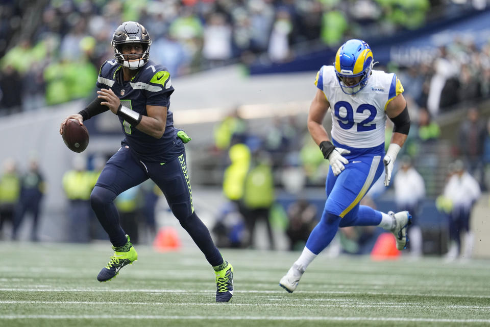 Seattle Seahawks quarterback Geno Smith (7) runs past Los Angeles Rams defensive tackle Jonah Williams (92) during the first half of an NFL football game Sunday, Jan. 8, 2023, in Seattle. (AP Photo/Abbie Parr)