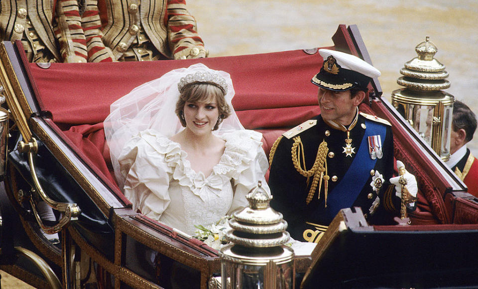 Prince Charles, Prince of Wales and Diana, Princess of Wales, wearing a wedding dress designed by David and Elizabeth Emanuel and the Spencer family Tiara, ride in an open carriage, from St. Paul's Cathedral to Buckingham Palace, following their wedding on July 29, 1981 in London, England.<span class="copyright">Anwar Hussein—WireImage via Getty Images</span>