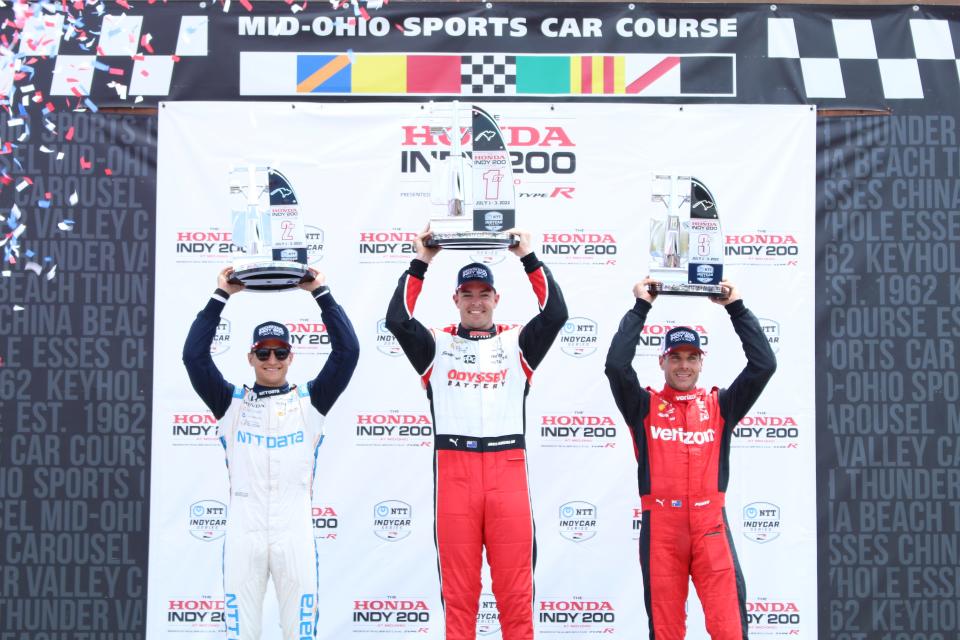 Honda Indy 200 winner Scott McLaughlin (center) holds the first-place trophy next to second-place finisher Alex Palou (left) and third-place finisher Will Power (right).