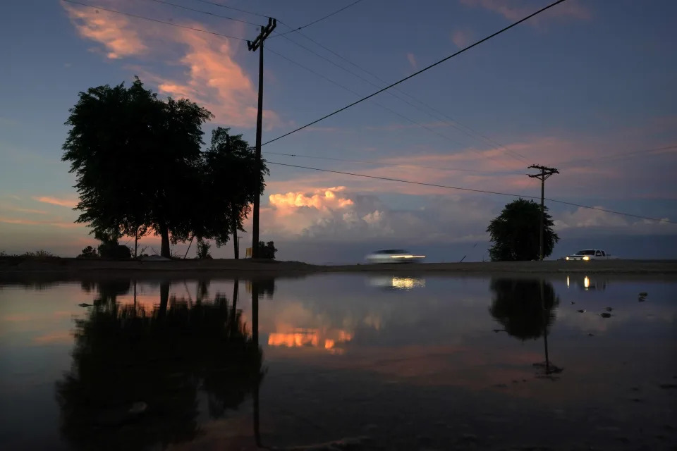 A small pond sits between a field irrigated with water from the All-American Canal and a highway, Sunday, Aug. 14, 2022, near Brawley, Calif. The canal conveys water from the Colorado River into the Imperial Valley. (AP Photo/Gregory Bull)