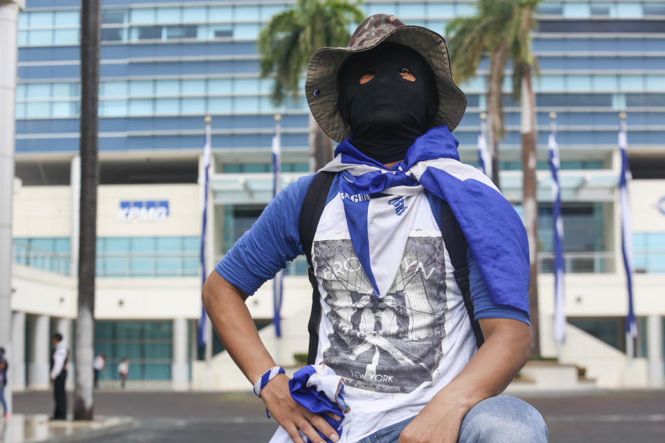 A masked demonstrator takes part in an anti-government march dubbed, "Nothing is Normal” in honor of slain student Matt Romero, in Managua, Nicaragua, Saturday, Sept. 21, 2019. 16-year-old Matt Romero was killed during “crossfire” last September when armed men wearing hoods clashed with anti-government protesters. (AP Photo/Alfredo Zuniga)