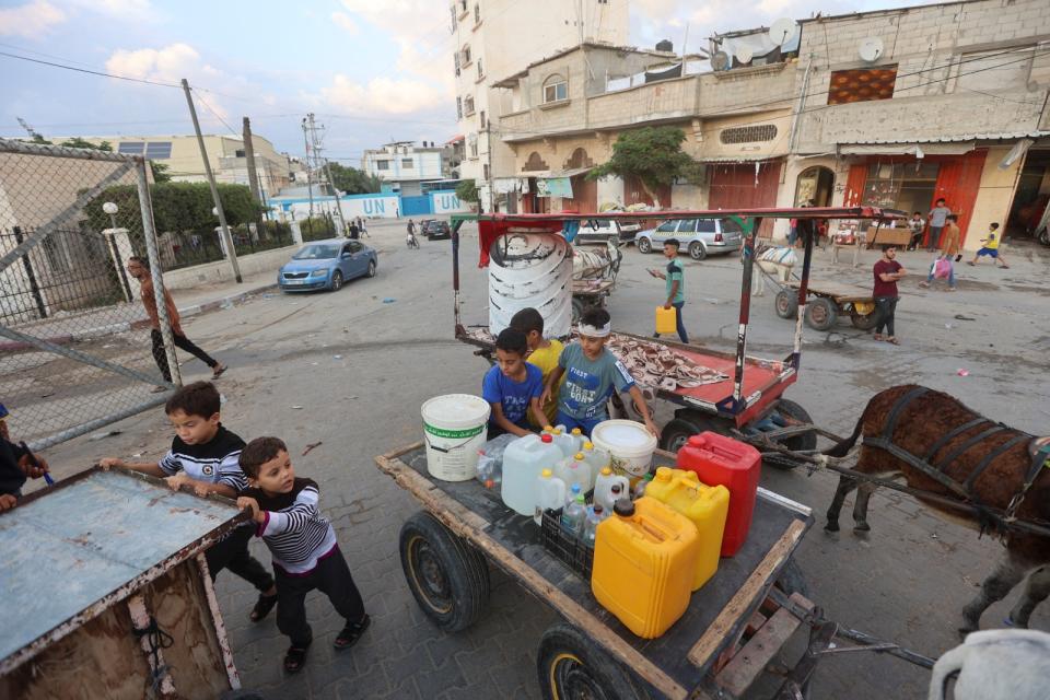 2023年10月14日，加薩走廊南部甘尤尼斯（khan younis）的巴勒斯坦兒童幫忙打水。路透社