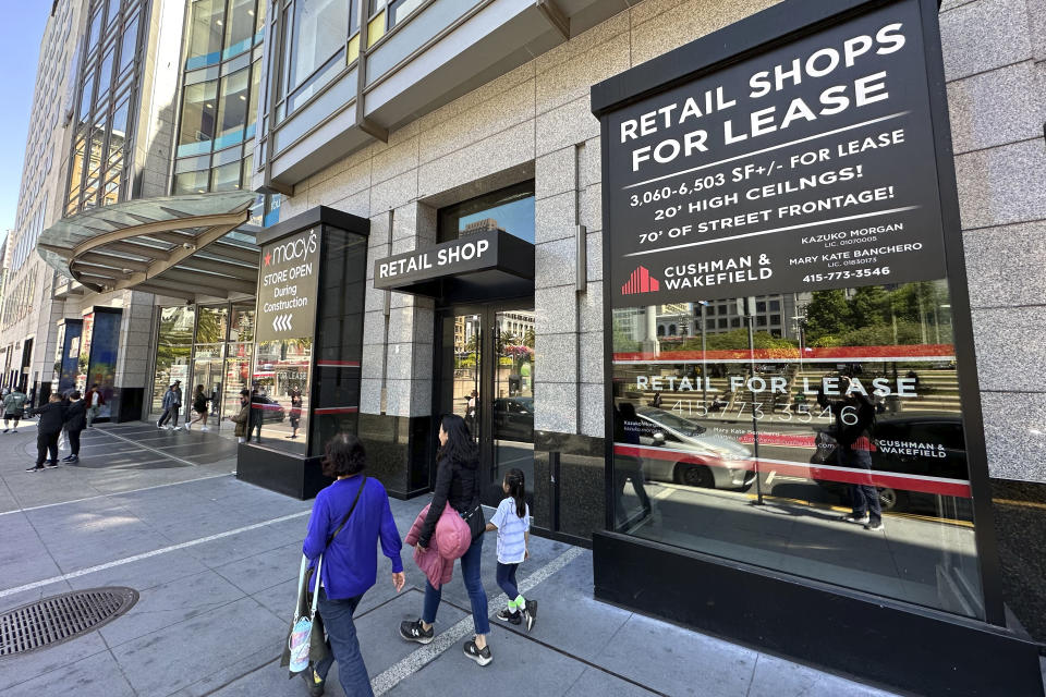 People make their way past retail spaces for lease at Union Square in San Francisco, on June 21, 2023. San Francisco's downtown has seen an exodus of retailers and now a shopping mall owner is turning the complex over to its lender in the face of declining foot traffic and empty office space. While San Francisco faces some of its own unique issues, such as a heavy reliance on tech workers, most of them working largely remotely, the problems serve as warning signs for other downtowns across the country, which are also feeling some pain. (AP Photo/Eric Risberg)