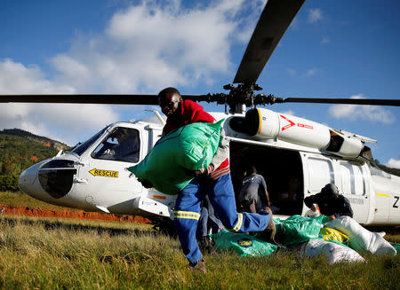 People receive food aid after Cyclone Idai from a helicopter drop at a distribution centre at Ngangu in Chimanimani, Zimbabwe, March 22, 2019. REUTERS/Philimon Bulawayo