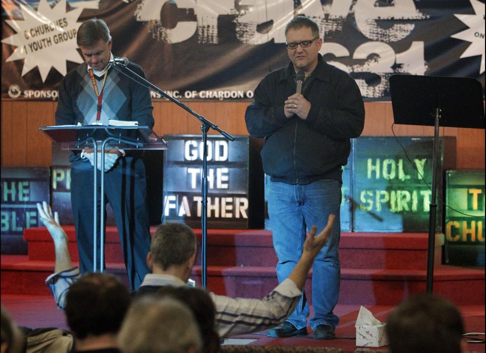 Rev. Jeff Johnson, left, and Bill Mullett lead prayers during a service for victims of a school shooting at Chardon Assembly of God in Chardon, Ohio Monday, Feb. 27, 2012. A gunman opened fire inside the high school's cafeteria at the start of the school day Monday, killing three students and wounding two others. (AP Photo/Mark Duncan)