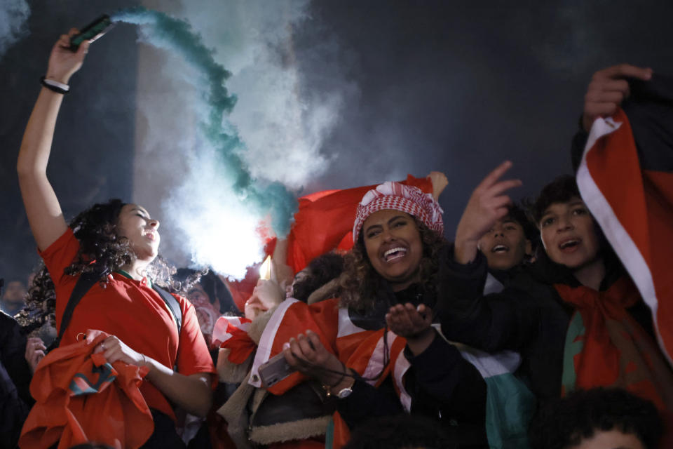 Moroccan fan light flares as they celebrate in Trafalgar Square in London Saturday, Dec. 10, 2022, after the World Cup quarterfinal match between Morocco and Portugal. Morocco won the game 1-0. (AP Photo/David Cliff )