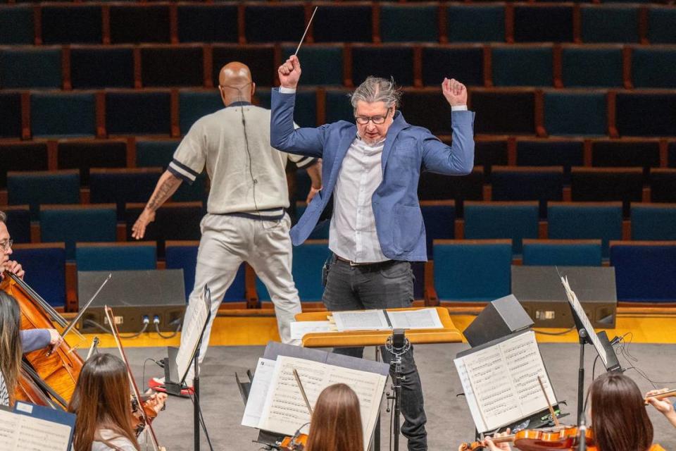 Conductor Tim Davies leads the Kansas City Symphony while rehearsing with Tech N9ne. Davies has directed other symphonies that have fused their performances with big name hip-hop artists.