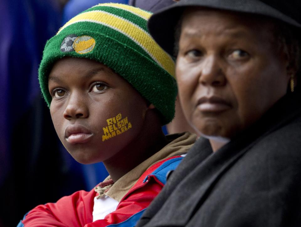 A boy with "Rest In Peace Nelson Mandela" painted on his face looks up at the podium during the memorial service for former South African president Nelson Mandela at the FNB Stadium in Soweto, near Johannesburg, South Africa, Tuesday Dec. 10, 2013. (AP Photo/Peter Dejong)